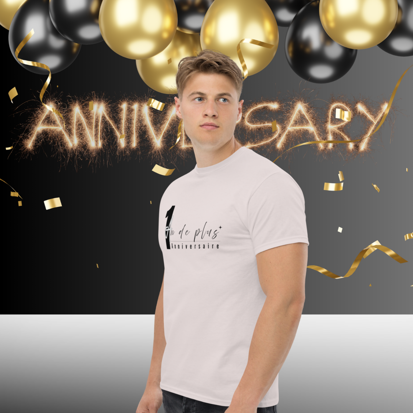 Man wearing white “1 Year More Anniversary” t-shirt posing in front of gold and black balloons with festive anniversary party background