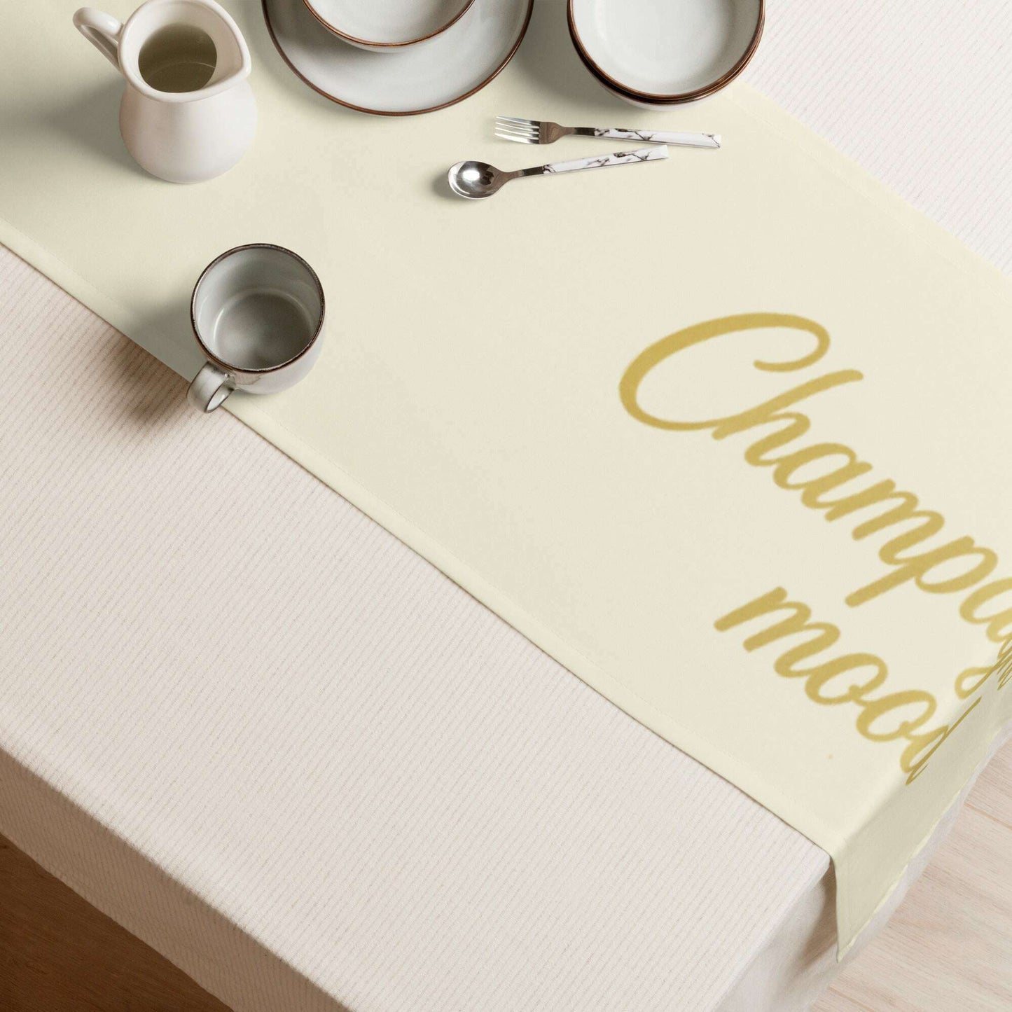 White table runner with gold Champagne Time text displayed on table corner, minimalist white and gold decor for wedding party or bachelorette celebration