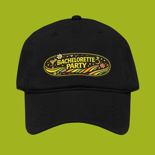 Front view of black cotton bachelorette party cap with retro festival design and adjustable fit