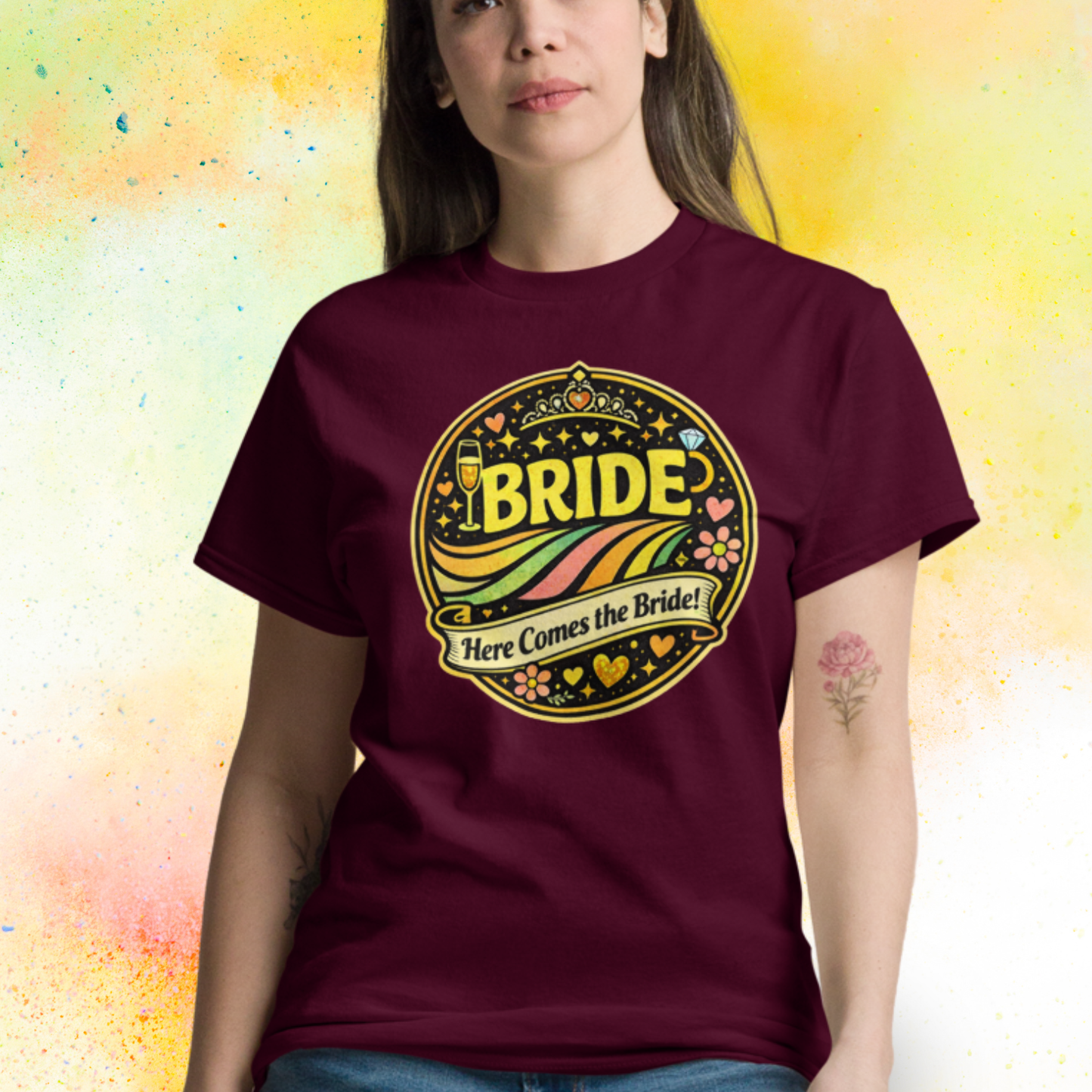 Woman wearing Bride Here Comes the Bride retro festival style t shirt with colorful vintage design, perfect outfit for bachelorette party and bridal celebration weekend burgundy
