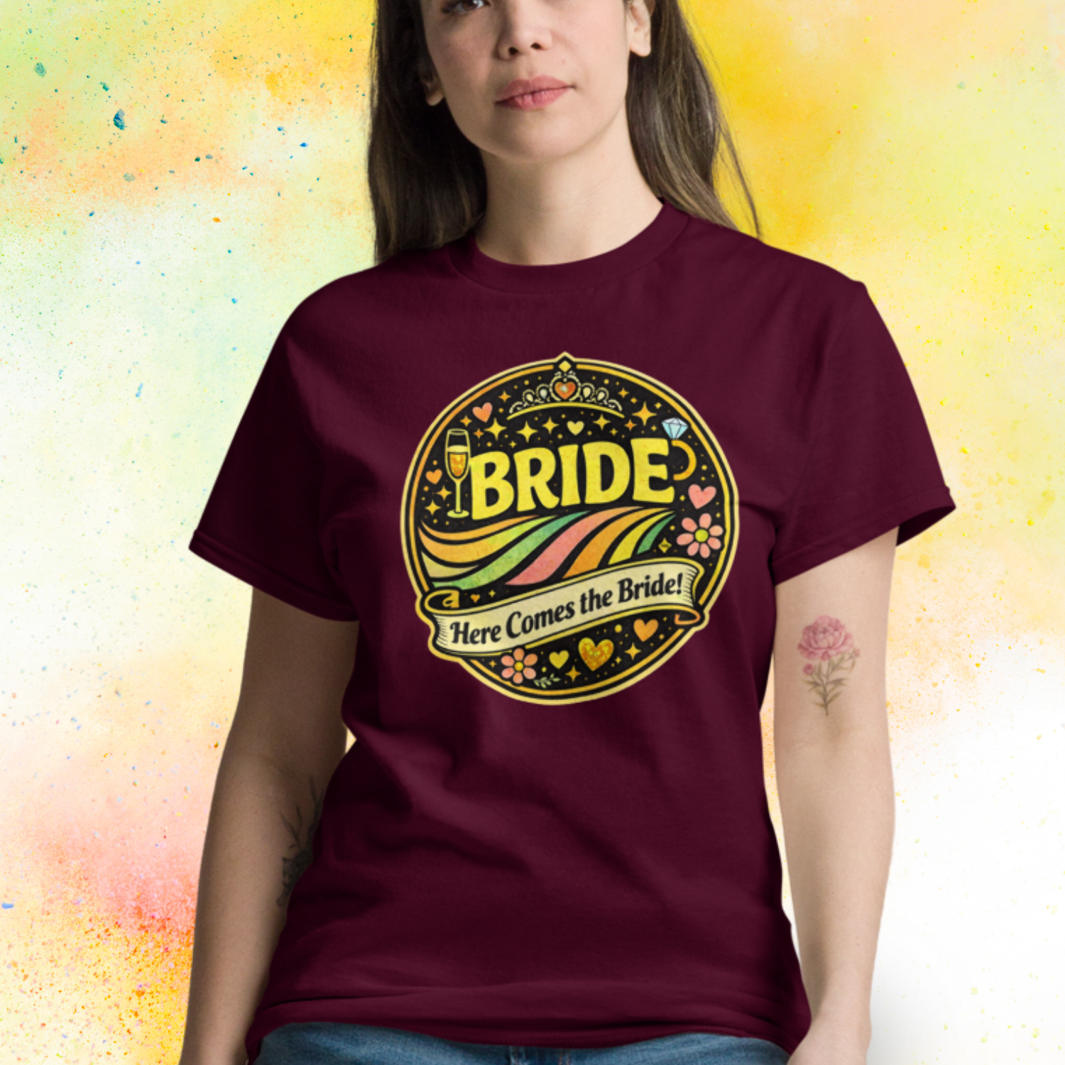 Woman wearing Bride Here Comes the Bride retro festival style t shirt with colorful vintage design, perfect outfit for bachelorette party and bridal celebration weekend burgundy
