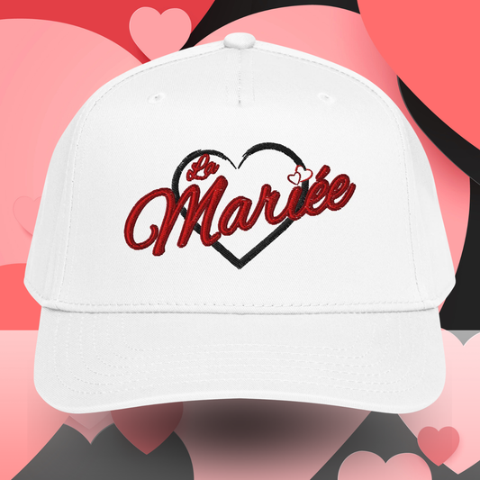 Casquette blanche La Mariee avec broderie rouge et coeur noir vue face, accessoire ideal pour future mariee lors dun EVJF.