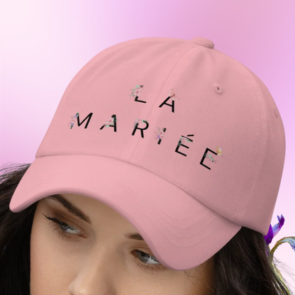 Casquette rose La Mariee avec design floral portee sur mannequin, accessoire tendance pour future mariee lors dun EVJF.