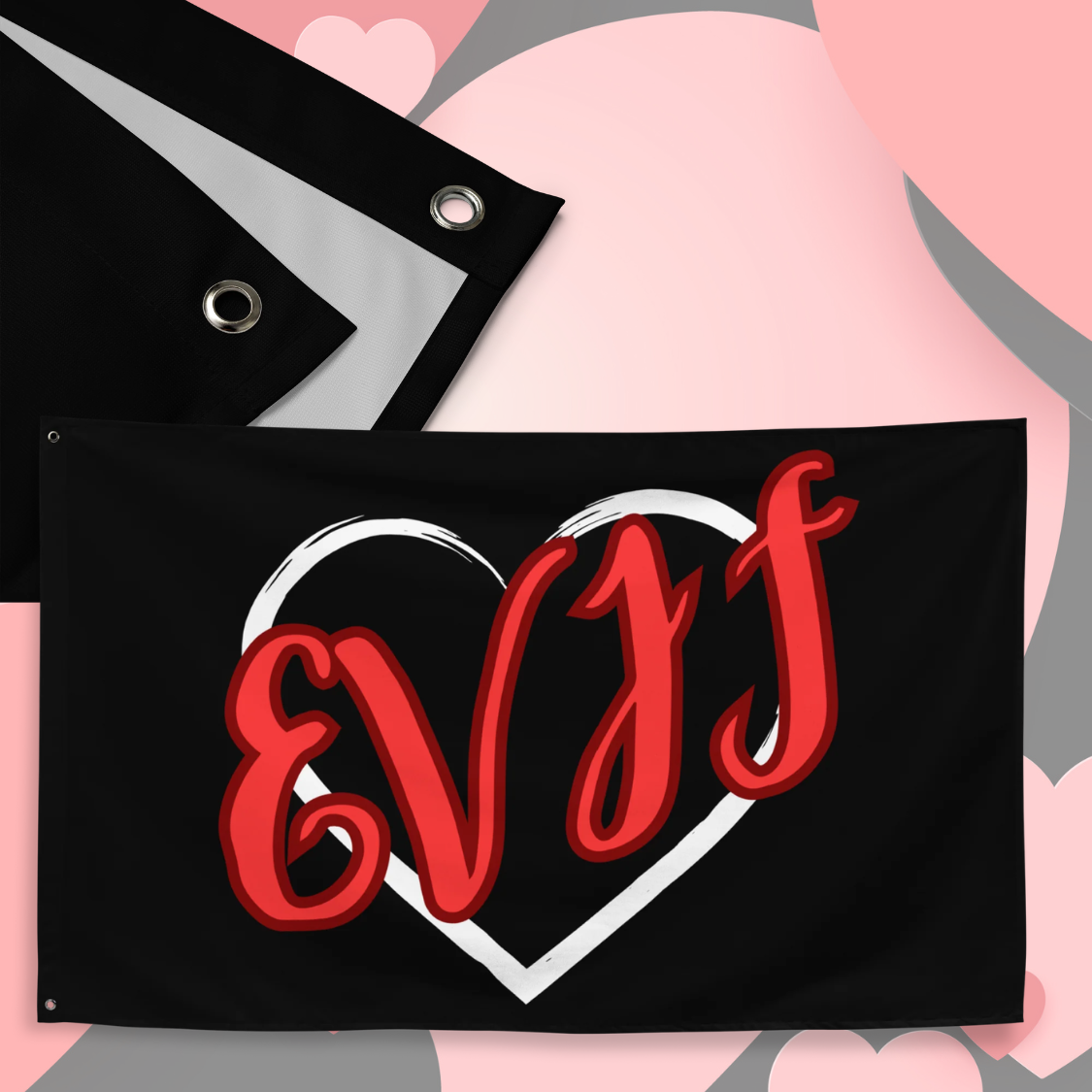 Drapeau EVJF noir avec lettres rouges montrant detail du tissu polyester et oeillet metallique pour suspension murale.