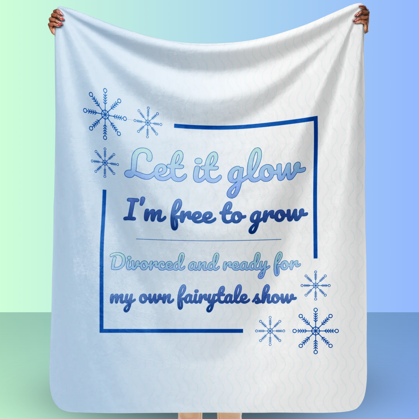 Person holding a Let it glow divorce party blanket with snowflake graphics and fairytale inspired message