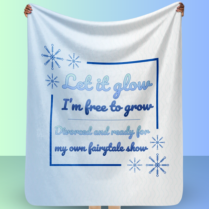 Person holding a Let it glow divorce party blanket with snowflake graphics and fairytale inspired message