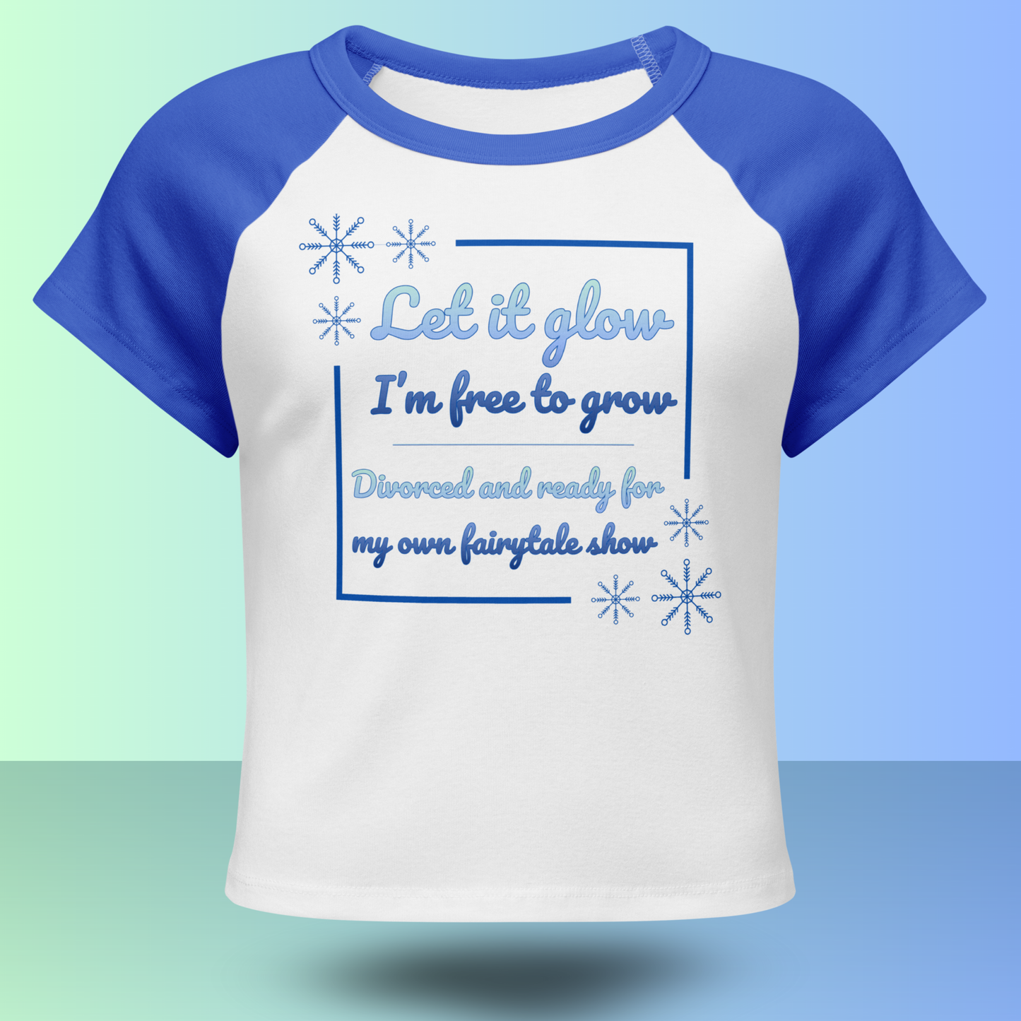 Front view of white and blue divorce party t-shirt with fairytale inspired Let it glow slogan and snowflake design
