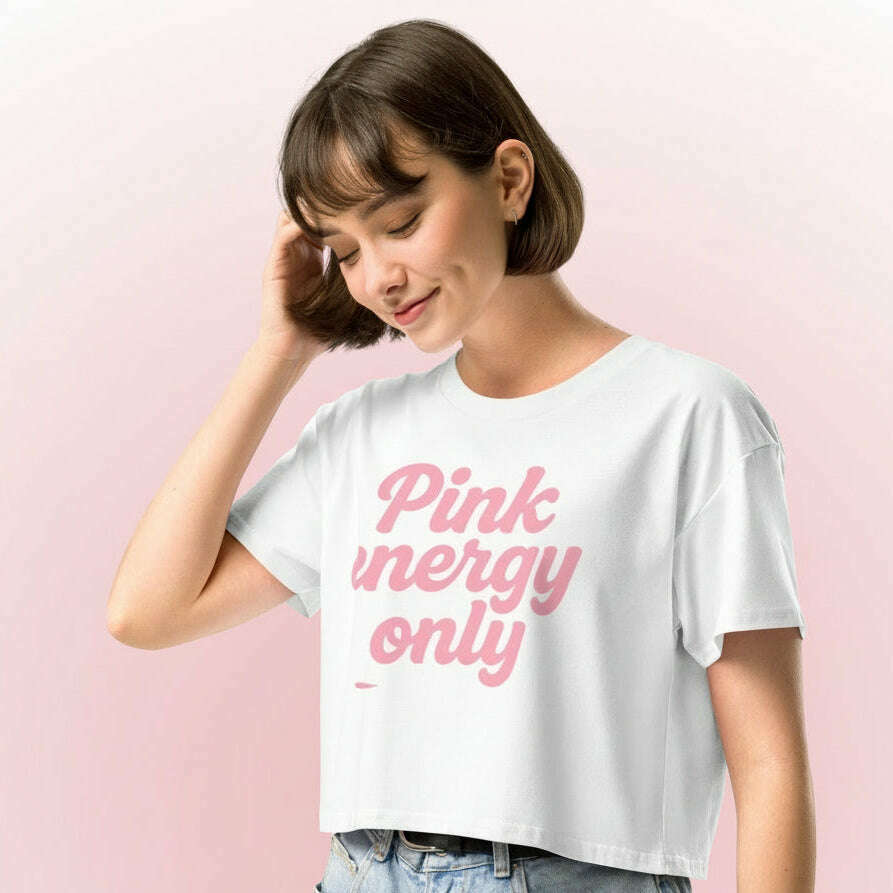 Woman wearing white crop top with pink “Pink Energy Only” graphic, stylish outfit for girls trip, festival or pink aesthetic look.