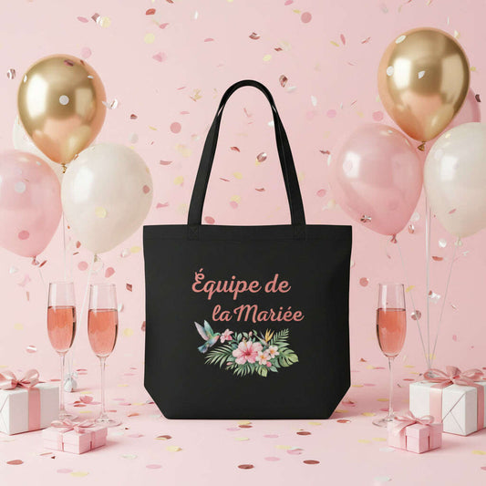 Tote bag noir EVJF avec inscription Equipe de la Mariee et motif floral tropical, sac pour bride squad ideal pour enterrement de vie de jeune fille, soiree entre filles et week end mariage.