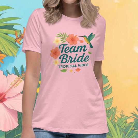 Woman wearing pink “Team Bride Tropical Vibes” t-shirt with tropical flowers and leaves, perfect outfit for beach bachelorette party, destination wedding or girls trip.