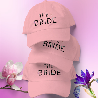 Stack of pink embroidered The Bride caps displayed together, perfect matching hats for bride during bachelorette party.