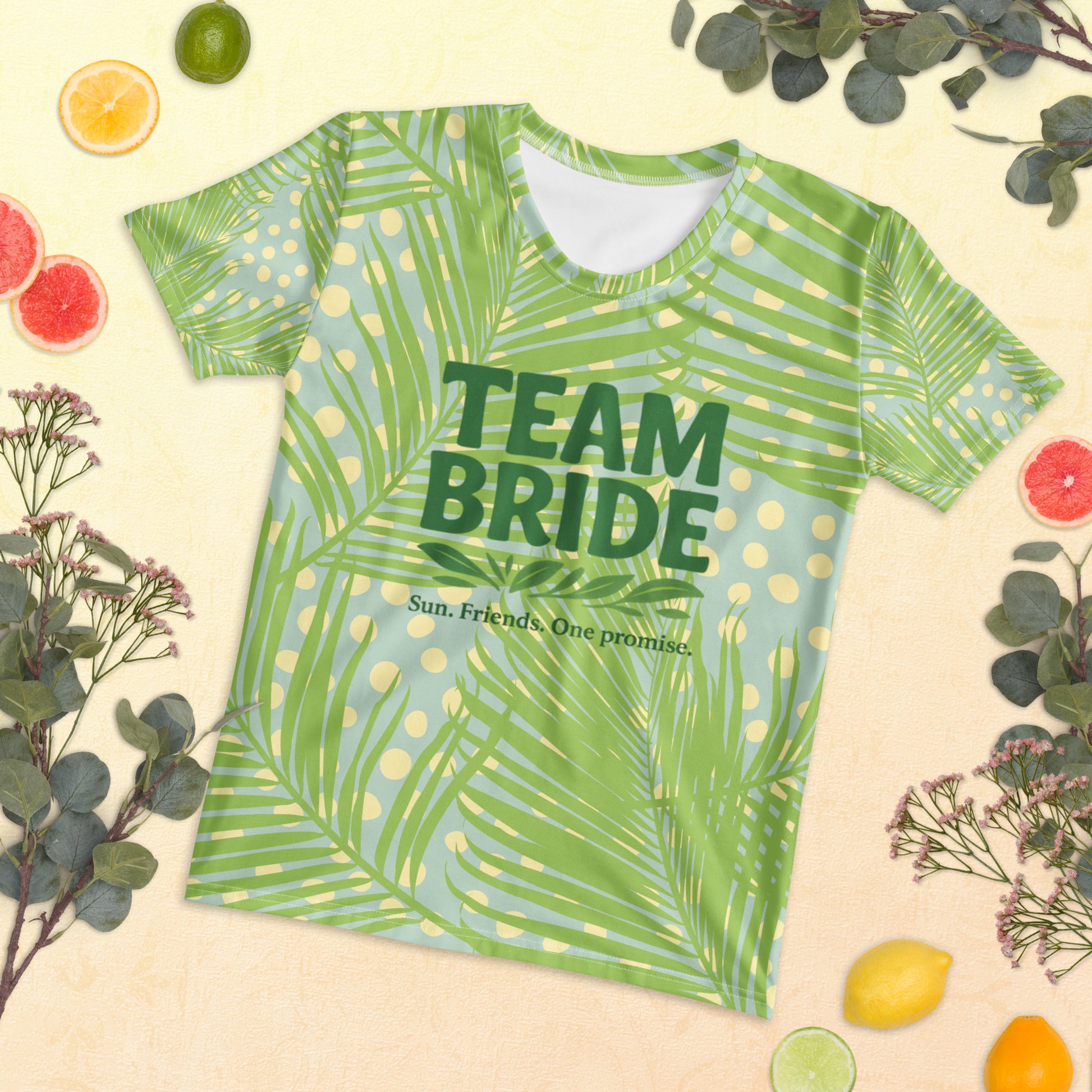 Model wearing the Tropical Team Bride t-shirt with jungle leaf print and pink slogan. The bright design and short-sleeve fit create a fresh summer look.