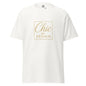 T-shirt blanc “Chic par Design” présenté sur fond lumineux. Le tissu premium et le slogan élégant créent un look épuré et parfaitement White & Gold.