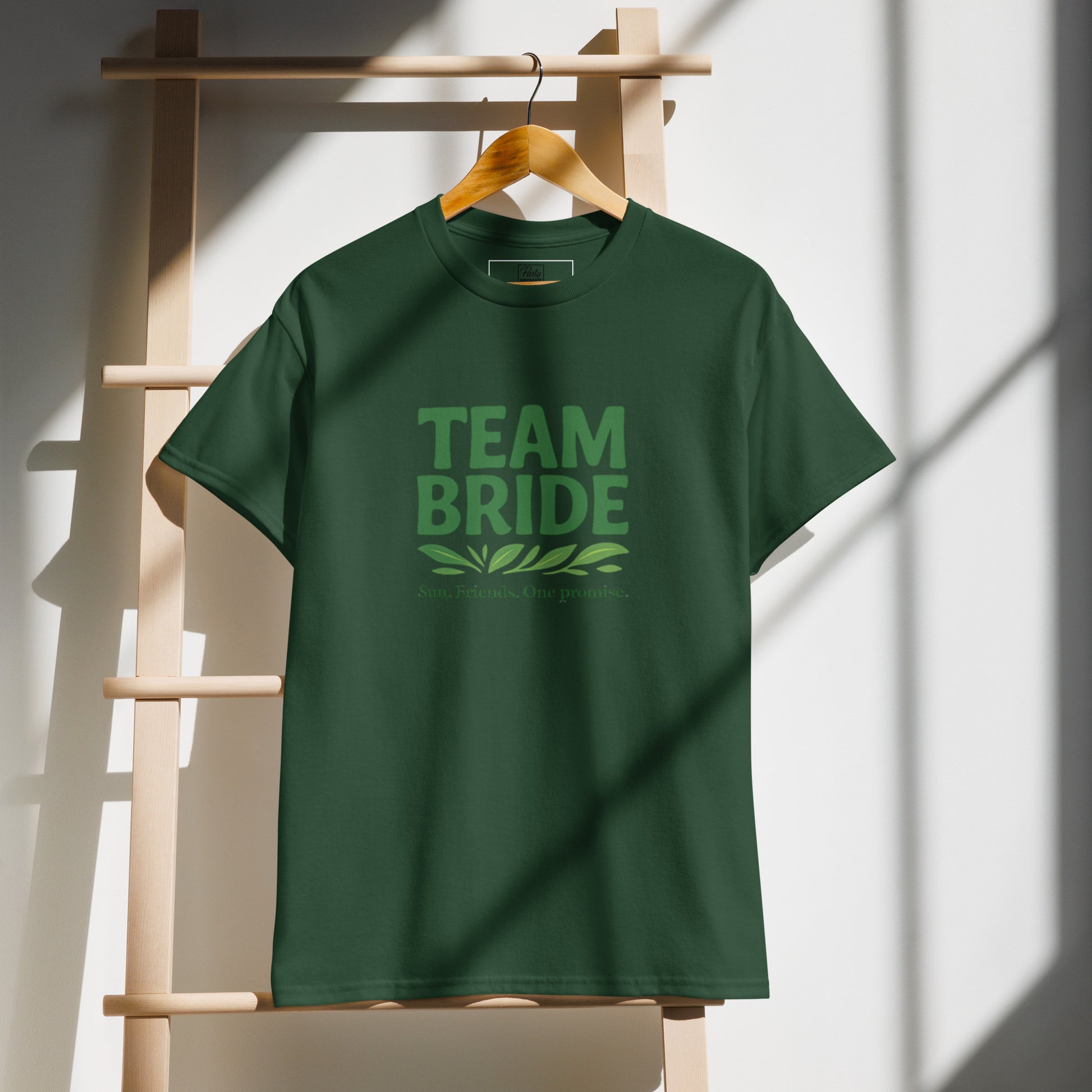 Photo de face sur cintre du t-shirt Team Bride couleur (Blanc / Sable / Citron Vert / Kelly Queen / Vert Forêt). Le slogan “Team Bride” est clairement visible et la couleur unie met en valeur le design simple et élégant.